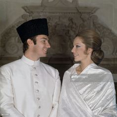 a man and woman dressed in white standing next to each other