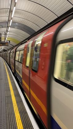 a red train traveling down tracks next to a loading platform