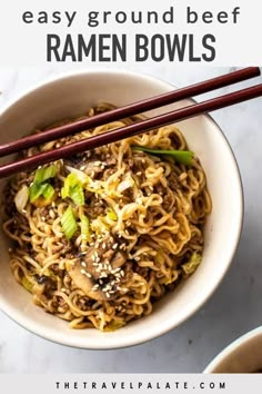 a bowl filled with noodles and chopsticks on top of a marble countertop