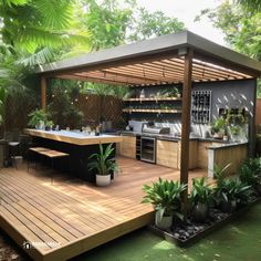 an outdoor kitchen with wooden decking surrounded by greenery and potted plant life