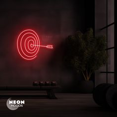 a red neon target in the center of a dark room with a bench and table