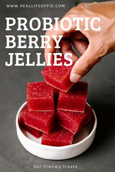 someone is picking up some red jellies out of a white bowl with the words probiotic berry jellies on it