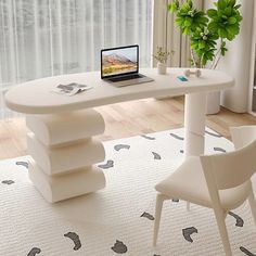 a laptop computer sitting on top of a white table next to a chair and potted plant