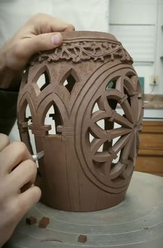 a person is working on a clay vase