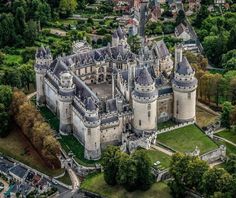 an aerial view of a castle surrounded by trees