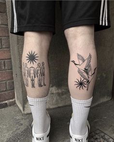 two people with tattoos on their legs standing next to each other