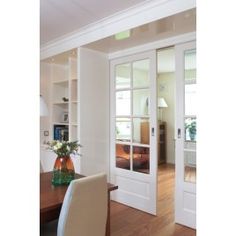 a dining room table and chairs with glass doors