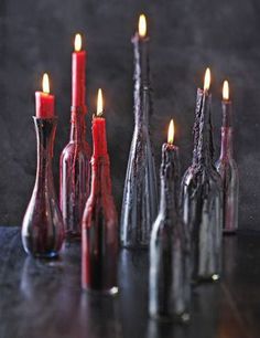 several bottles with candles in them sitting on a table