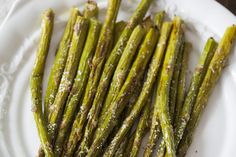 asparagus spears on a white plate with parmesan sprinkles