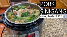 a pot filled with meat and vegetables on top of a kitchen counter next to an oven