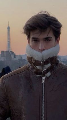 a man with a fake moustache standing in front of the eiffel tower