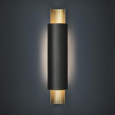 a black and gold wall light against a dark background