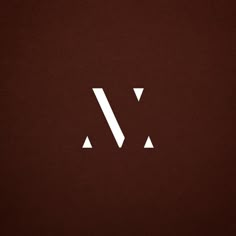 the letter w is made up of two white triangles on a dark brown paper background