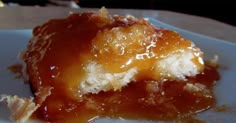 a piece of cake sitting on top of a white plate covered in caramel sauce