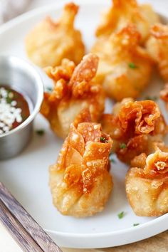 some fried food on a white plate with dipping sauce