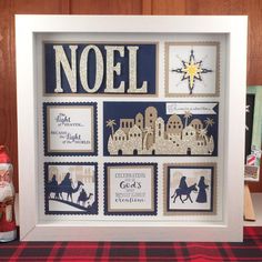 a framed nativity scene with the word noel in gold and blue, surrounded by christmas decorations