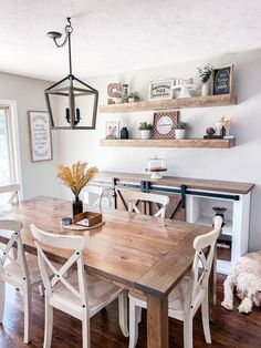 a dining room table with chairs and a dog sitting on the floor next to it