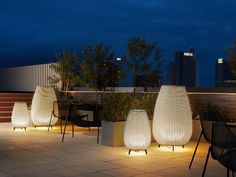 some chairs and lights on a roof at night