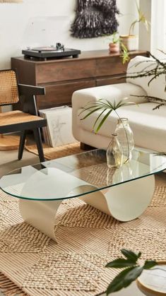 a living room filled with furniture and a glass coffee table on top of a rug