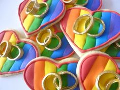 heart shaped cookies decorated with rainbow colors and gold rings