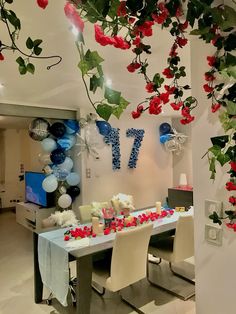 a room decorated with balloons and flowers on the ceiling, along with decorations for an event