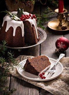 two bundt cakes on plates with white icing and pomegranates