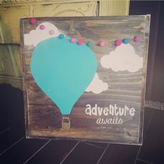 a wooden sign with an air balloon painted on it