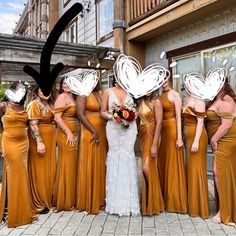 a group of women standing next to each other in front of a building with paper butterflies on their heads