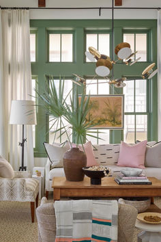 a living room filled with furniture and a large window covered in green shuttered windows