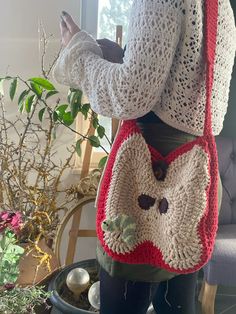 a woman wearing a red and white crocheted purse