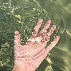 a person's hand is submerged in water