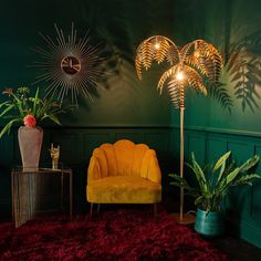 a living room with green walls and two chairs in front of plants on the floor