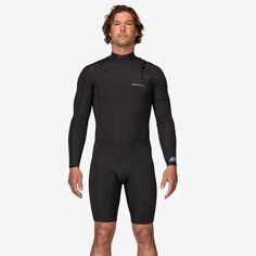 a man in a wetsuit is standing with his hands on his hips and looking off to the side