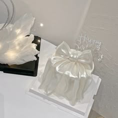 two white vases sitting on top of a table next to each other with lights in them