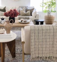 a living room filled with lots of furniture and flowers in vases on the coffee table