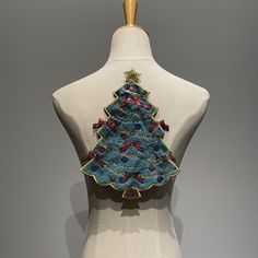 a white mannequin with a blue and red christmas tree on it's back