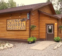 a wooden building with a sign that says flying squirrel bakery - cafe on the front