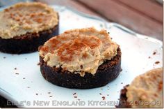 three chocolate cupcakes with frosting and cinnamon on top sitting on a plate