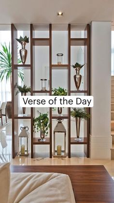 a living room filled with lots of furniture and plants on shelves next to a stair case