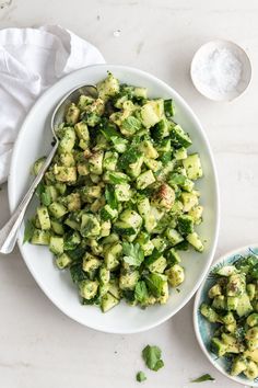 a white bowl filled with cucumber salad on top of a table