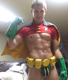 a man in a green and yellow costume is posing for the camera with his hands on his hips