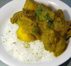 a white plate topped with rice and meat