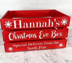 three red christmas eve boxes with snowflakes on the top and bottom, sitting on a marble surface