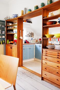 a wooden table sitting in front of a kitchen filled with lots of cupboards and bowls