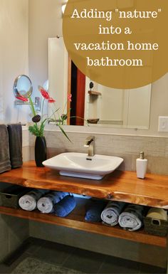 a bathroom with a sink, mirror and towels on the counter in front of it