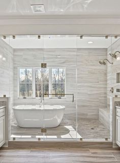 a large white bath tub sitting inside of a bathroom next to a walk in shower