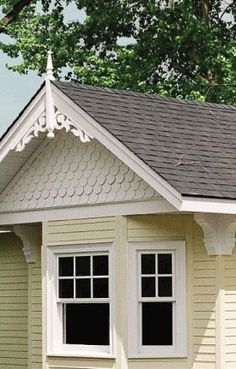 a small yellow house with white trim and windows