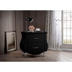 a night stand with two drawers in front of a window next to a framed photograph