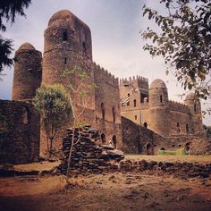 an old stone castle sitting on top of a dirt field