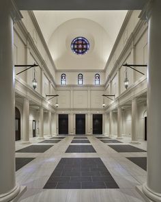 an empty building with columns and stained glass windows